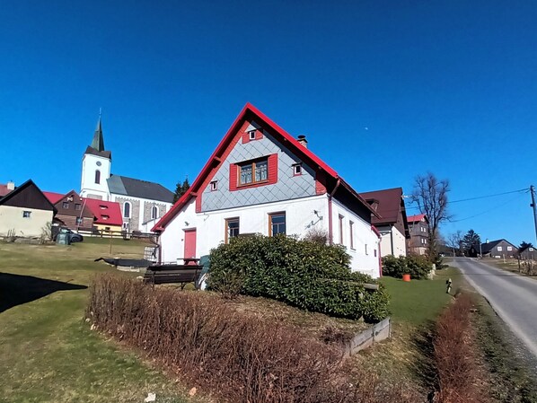 A white building with a red roof and a small garden in front. - Jizerky Paws & Sauna by Interhome (Tanvald)