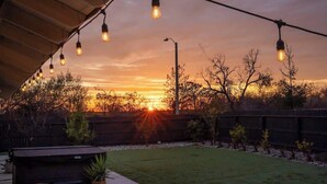 A backyard with a barbecue area, string lights, and a sunset view. - Agave Zen House w/ Hot Tub & BBQ Grill! (Porterville)