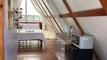 A bedroom with a bed, bedside table, and a window.