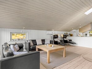 A modern interior with a wooden ceiling, a sofa, a table, and two massage chairs. - "Emila" - 2.2km from the sea by Interhome (Rømø)