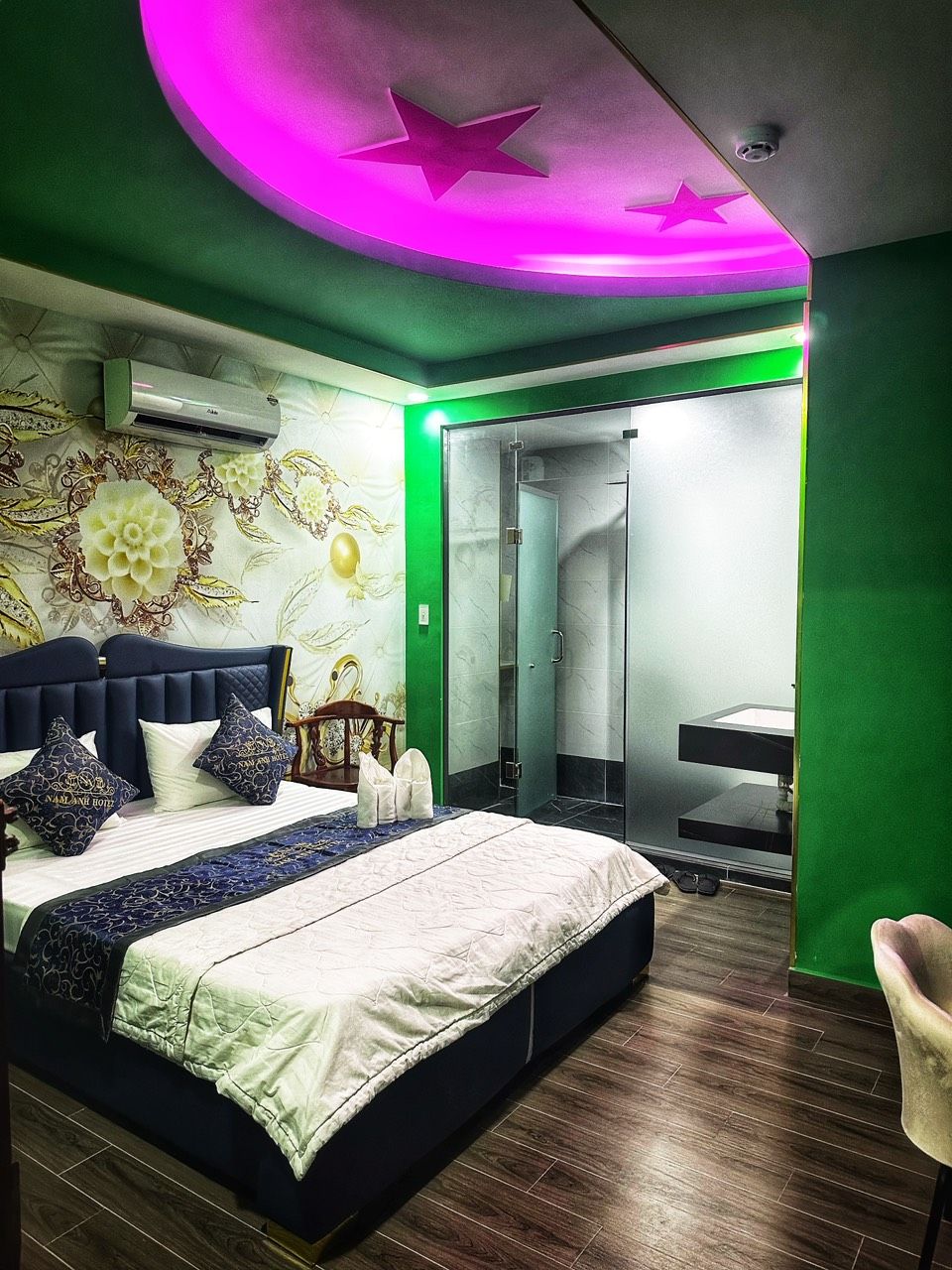 Ein modernes Schlafzimmer mit Bett, Schminktisch und einer Duschgelegenheit.
