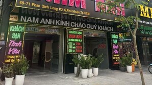 A hotel named "Nam Anh Kinh Chau Quy Khach" with a neon sign, potted plants, and a visible entrance. - Nam Anh Hotel Phu Nhuan -by Bay Luxury (Ho Chi Minh City)