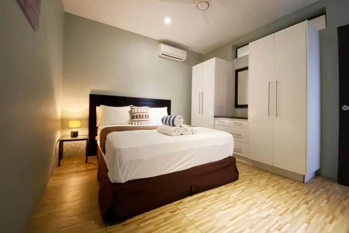 A bedroom with a bed, bedside table, and wardrobe.