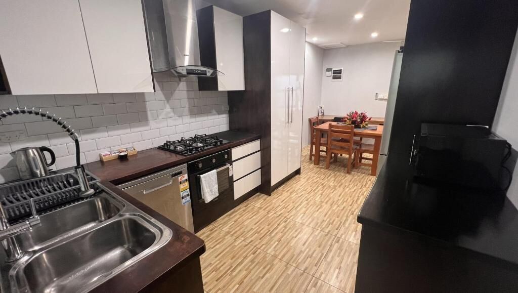 Cozinha moderna com fogão a gás, pia de aço inoxidável e geladeira preta.