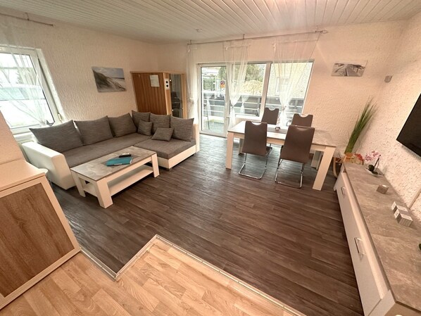 A modern living room with a sofa, coffee table, and dining area.