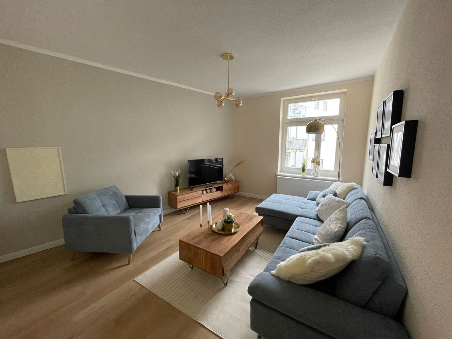 Ein modernes Wohnzimmer mit einer Couch, einem Couchtisch und einem Fernseher.