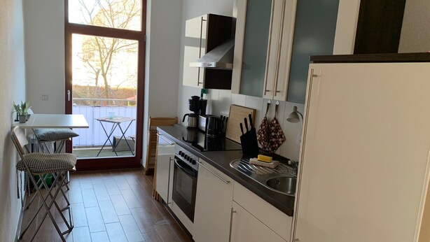 Cocina compacta con comedor, un ventanal y vistas al exterior.