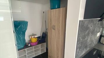 Eine Küche mit einem Holzkorpus, einem schwarzen Fliesenboden und einer Arbeitsplatte mit einem Spülbecken.