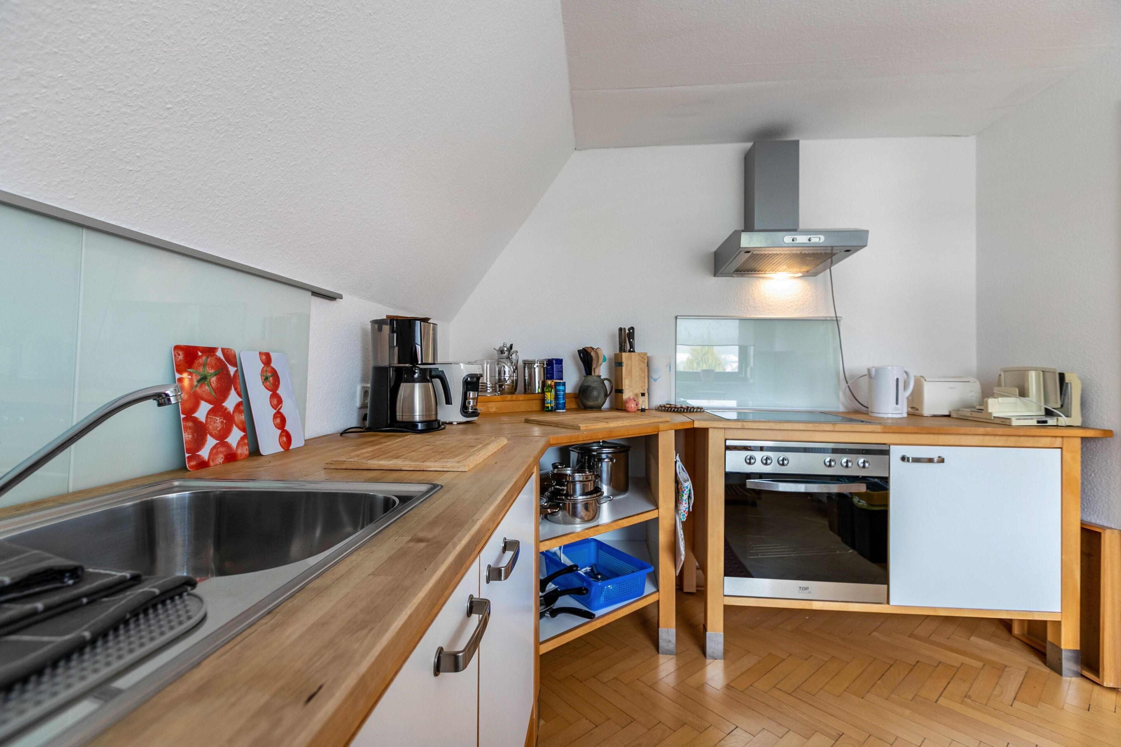 A modern kitchen with a stainless steel sink, a built-in oven, and a dishwasher.
