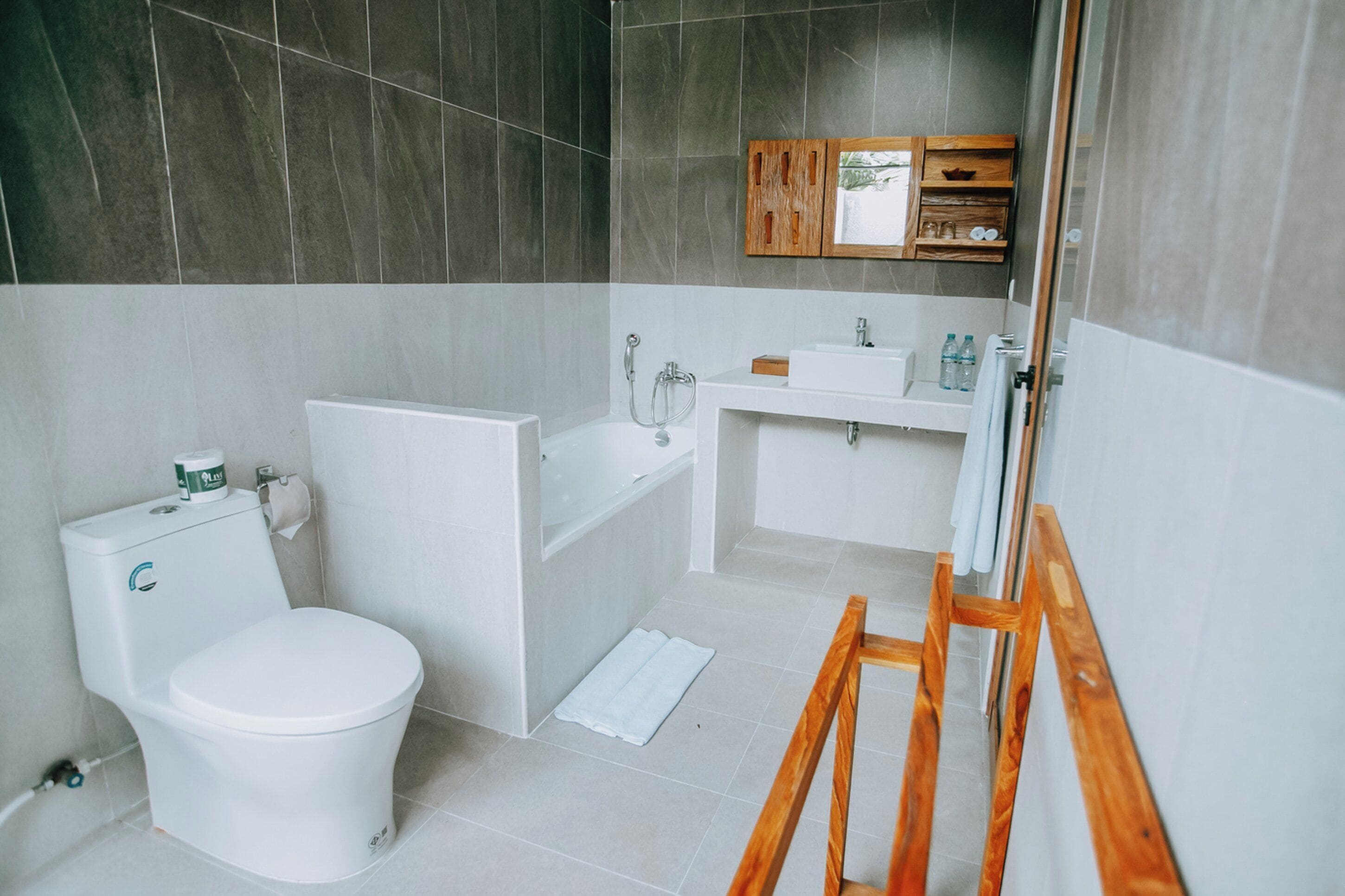 A modern bathroom with a toilet, bathtub, and sink.