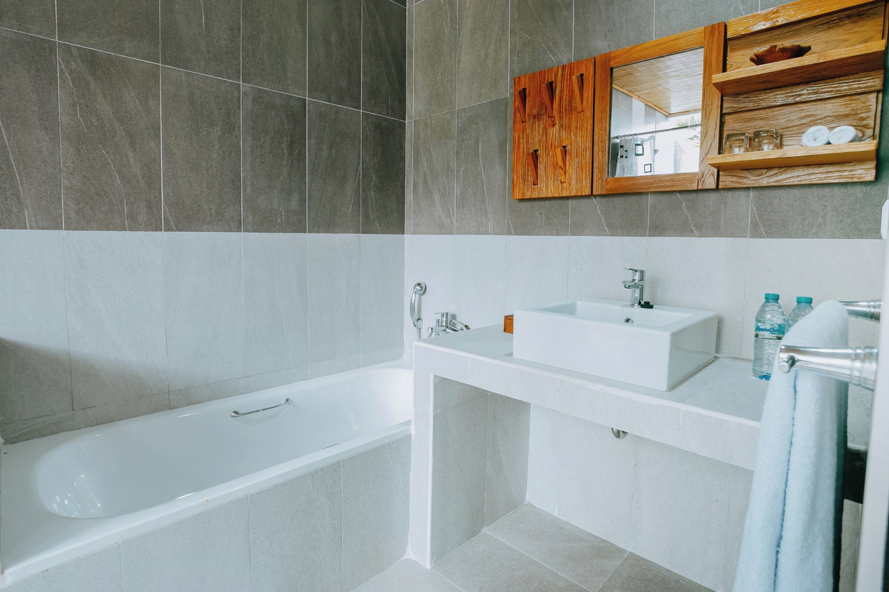 A modern bathroom with a bathtub, a sink, and a mirror.