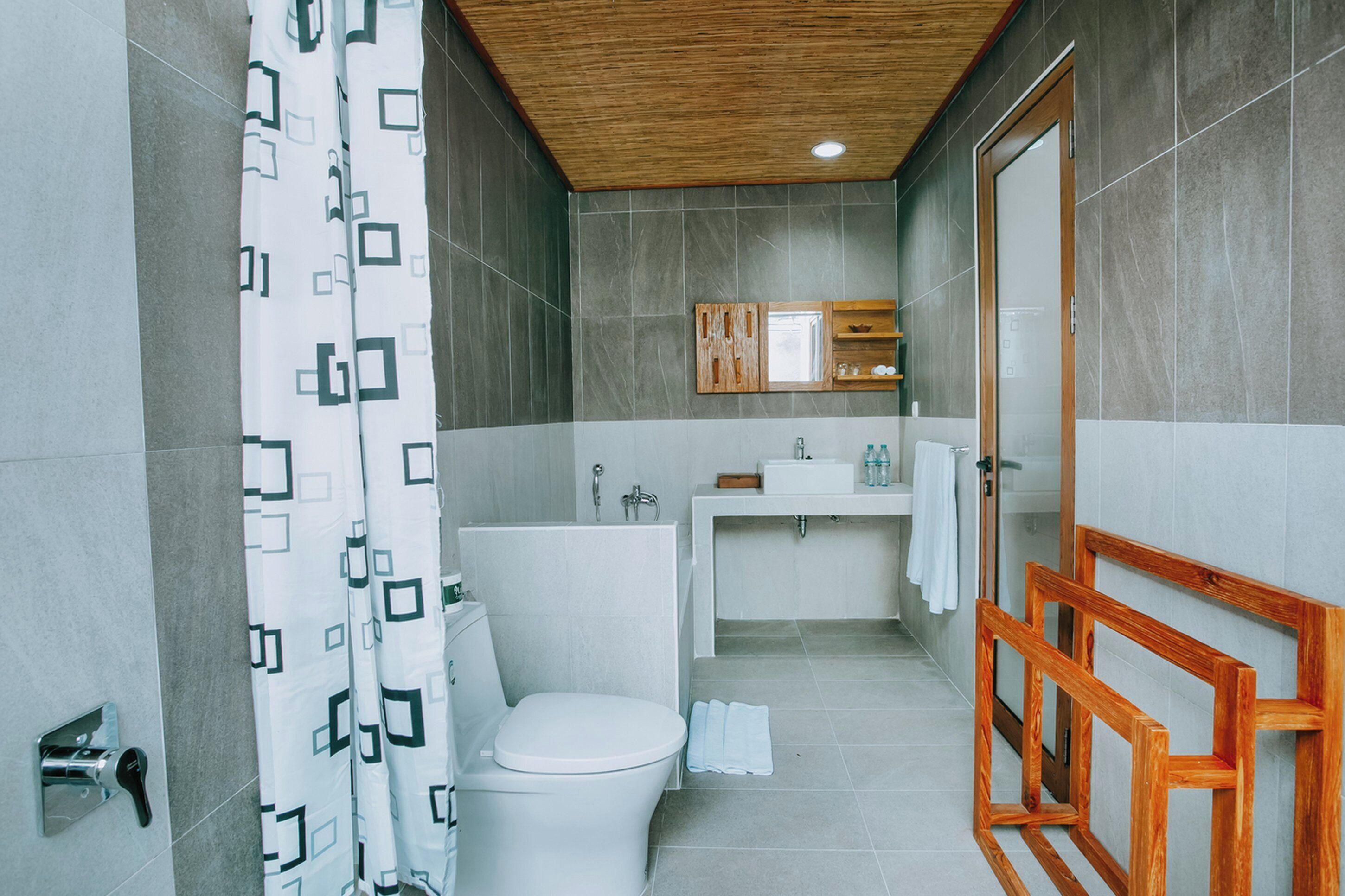 Ein modernes Badezimmer mit Toilette, Waschbecken und Duschbereich.