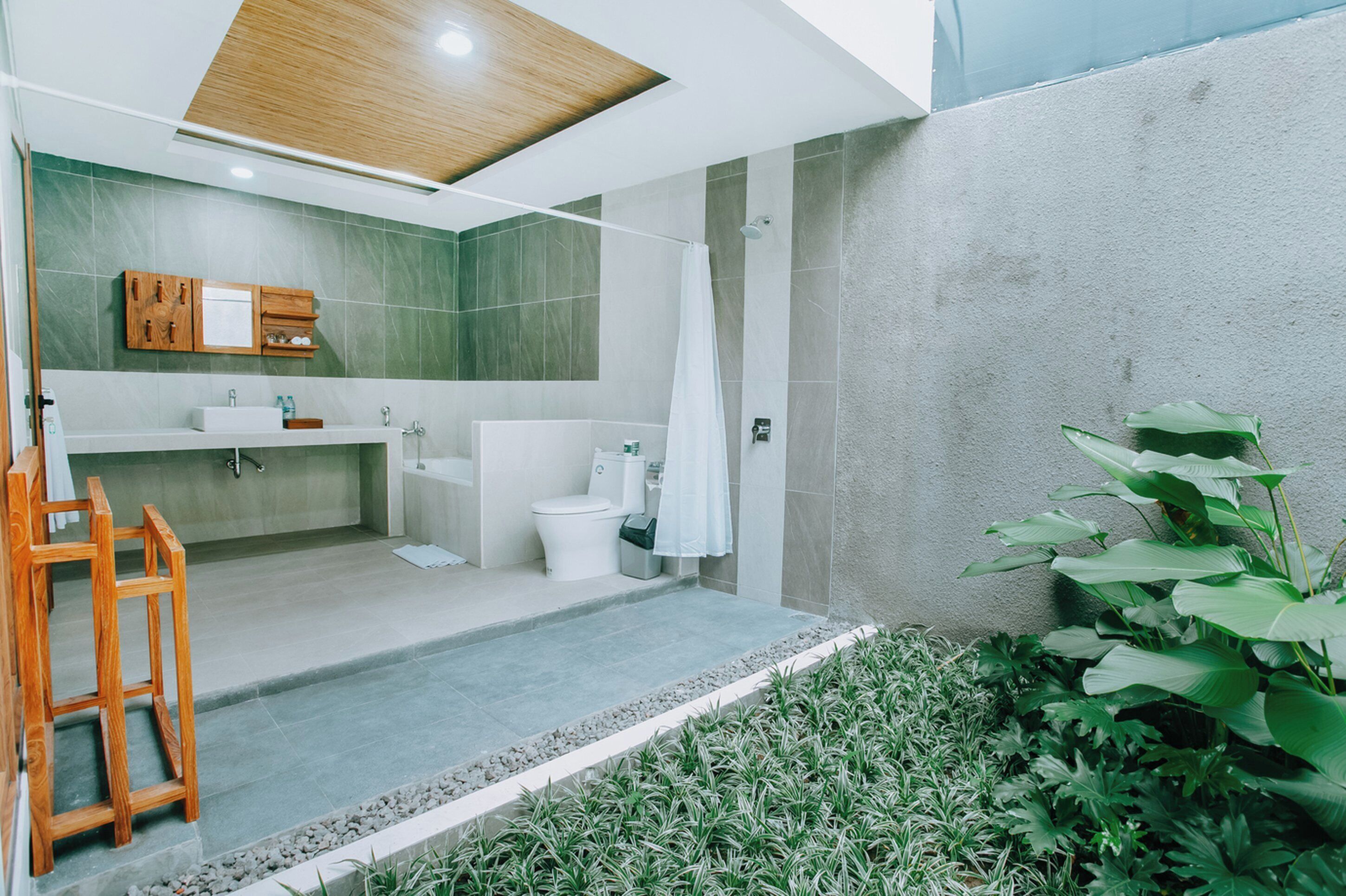 Ein modernes Badezimmer mit Dusche, Toilette, Waschbecken und Holzschrank.