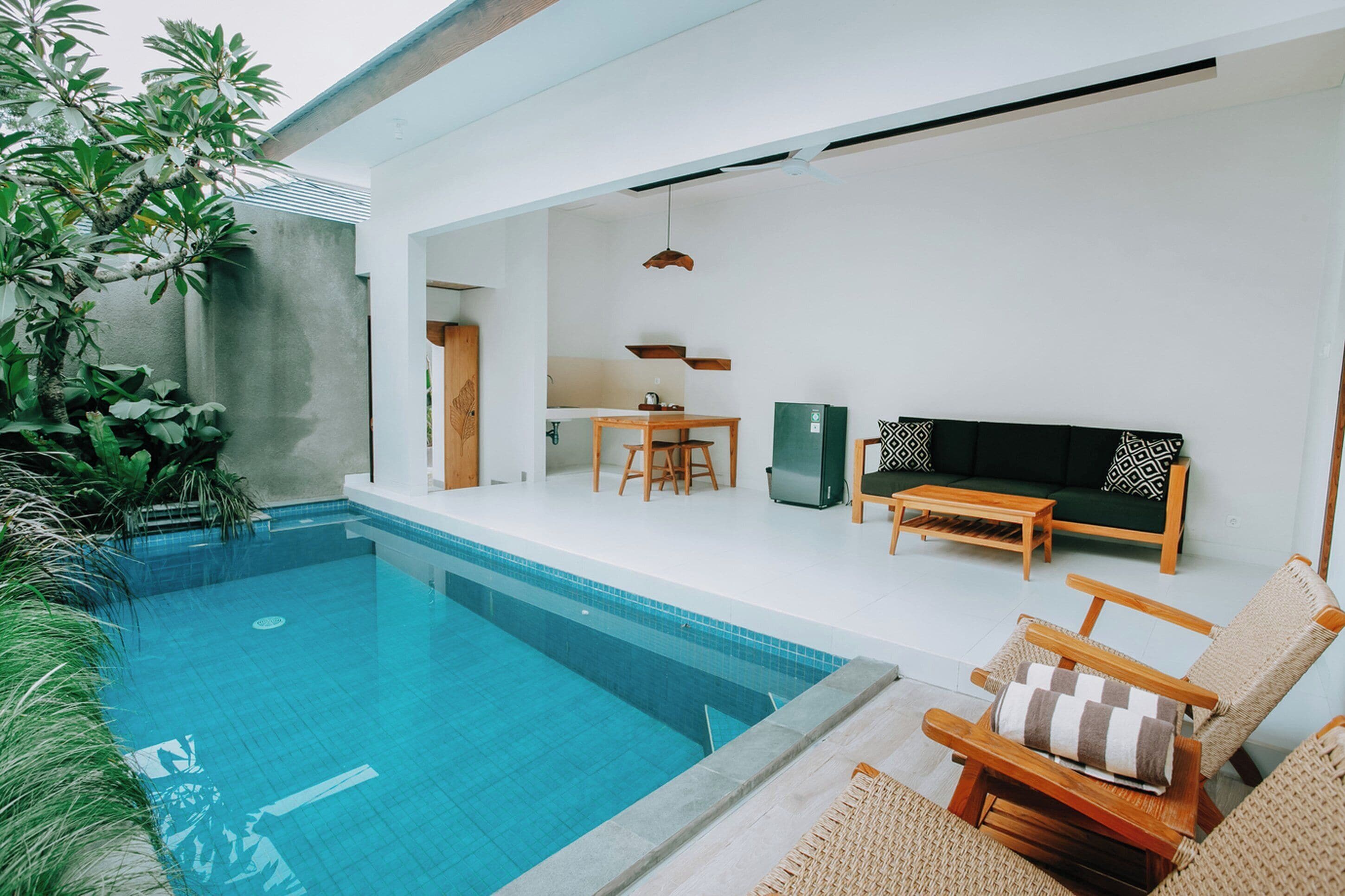 A modern pool area with a dining set and seating.