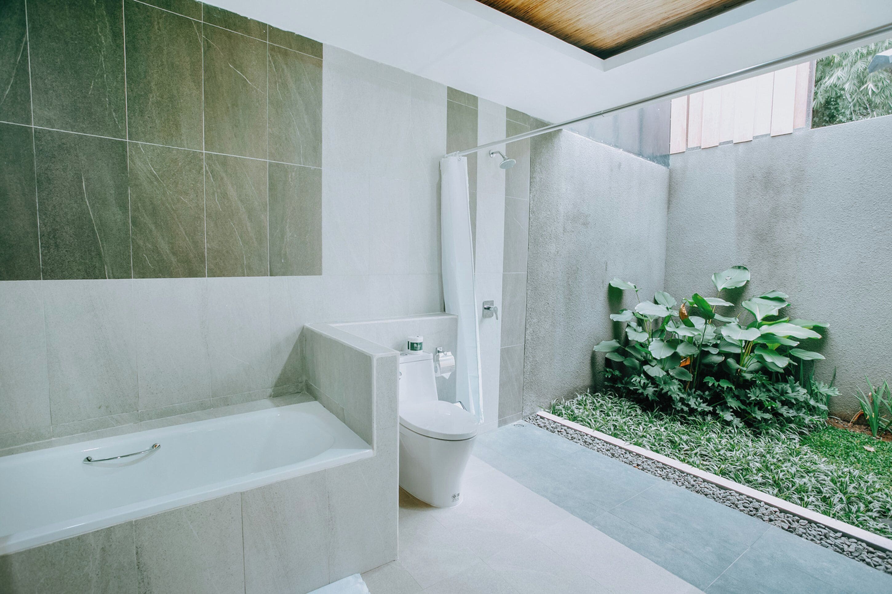 A modern bathroom with a bathtub, toilet, and shower area.