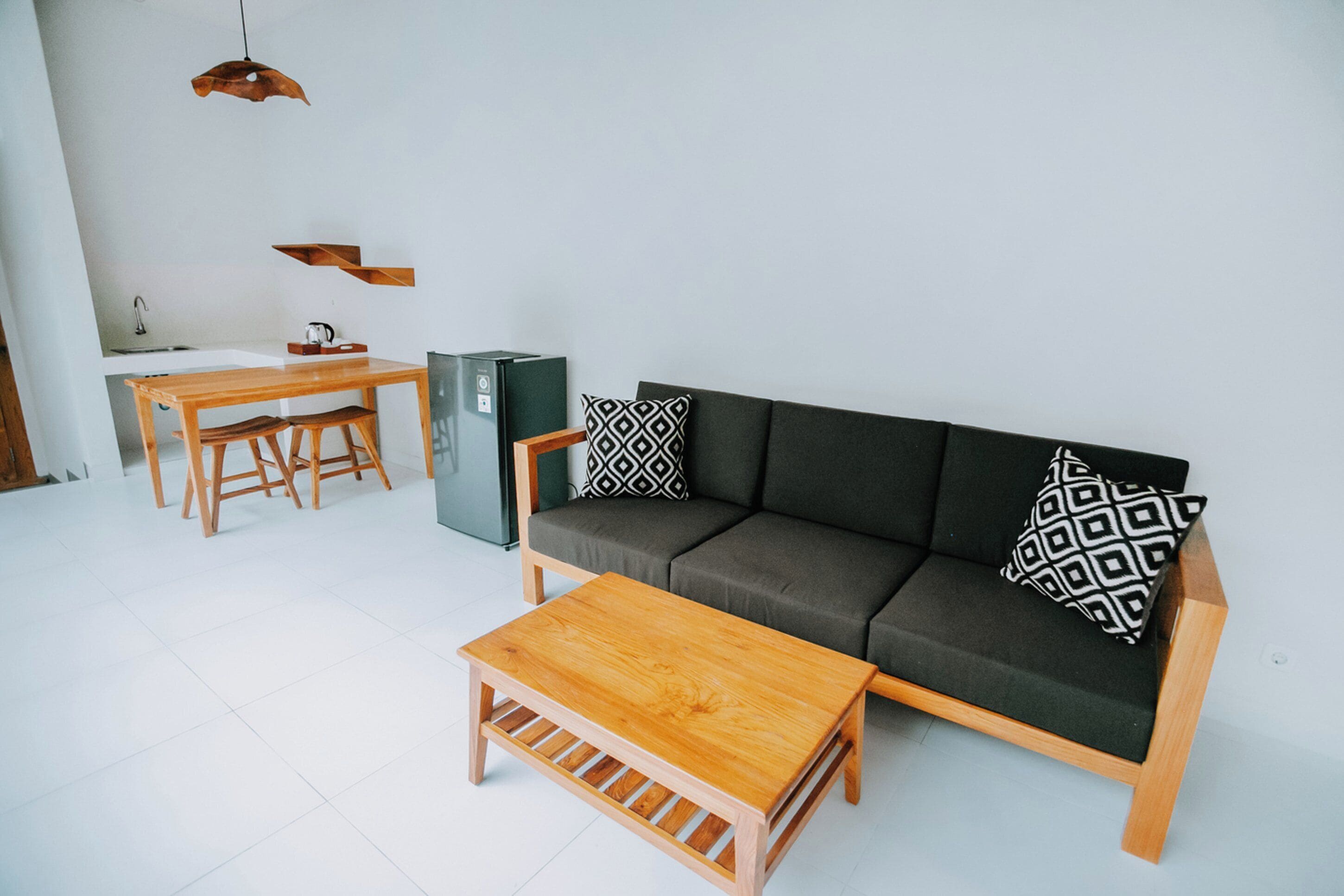 A modern living room with a sofa, coffee table, and dining table.