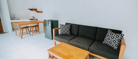 A modern living room with a sofa, coffee table, and dining table.