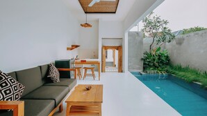 A modern living room with a pool, a dining area, and a kitchen. - Mahayoga Ubud Private Pool Villa Spa And Resto (Ubud)