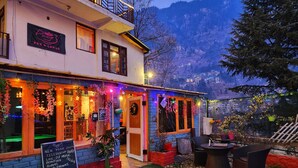 Un bar y albergue con un cartel que anuncia servicios como celebración de Año Nuevo, música de DJ en vivo, hoguera, comida y bebidas.