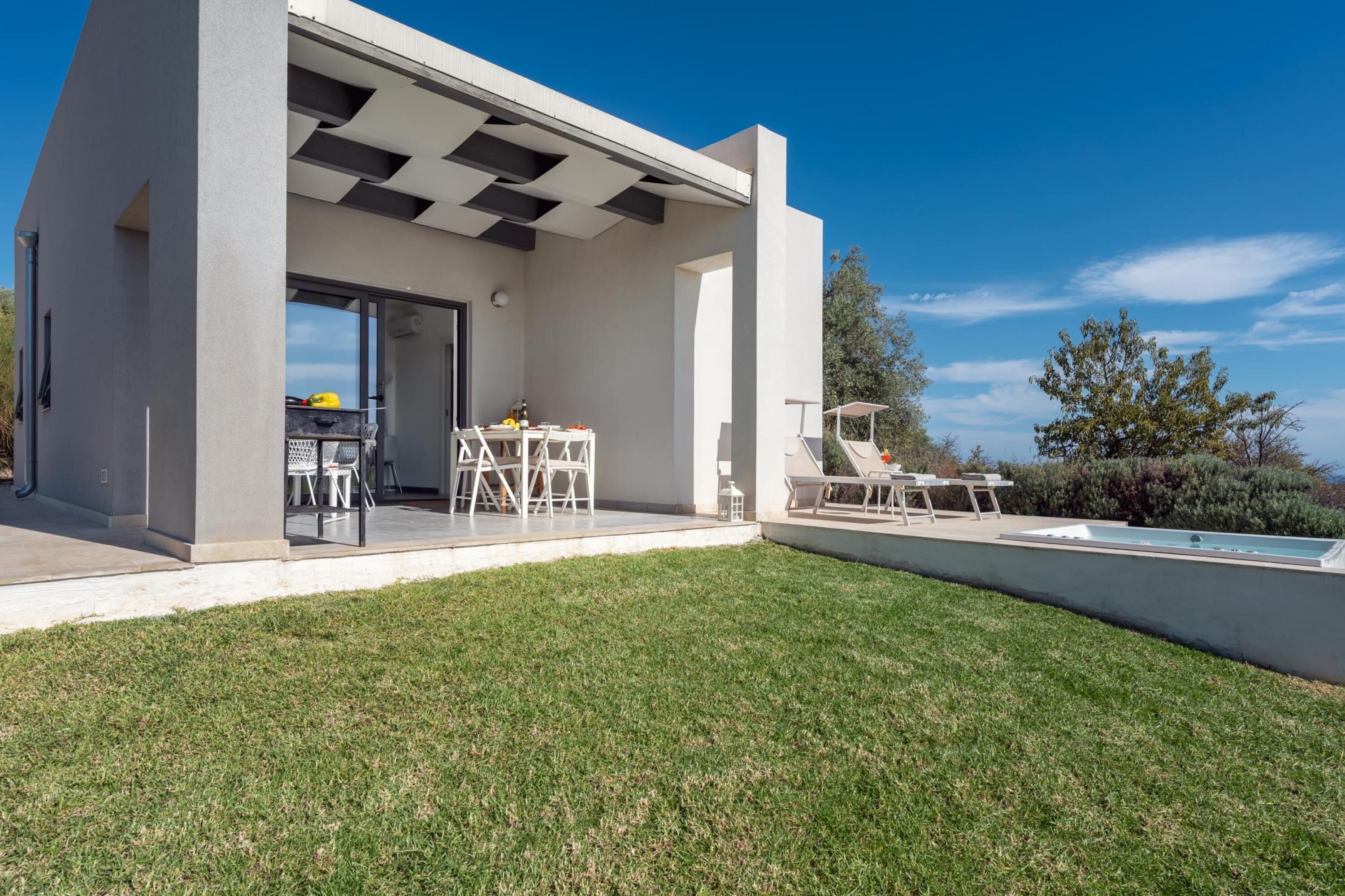 A modern house with a patio area featuring outdoor furniture and a swimming pool.