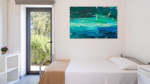 A bedroom with a bed, a bedside table, a window with a view of greenery, and a painting on the wall. - Villa Il Cavaliere Dependance by Elite Villas (Noto)