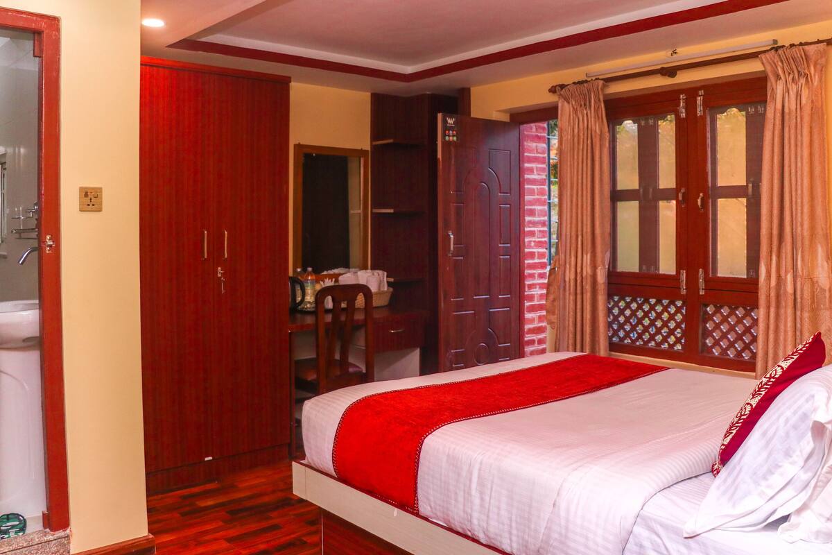 A bedroom with a bed, a wardrobe, a desk, and a bathroom.