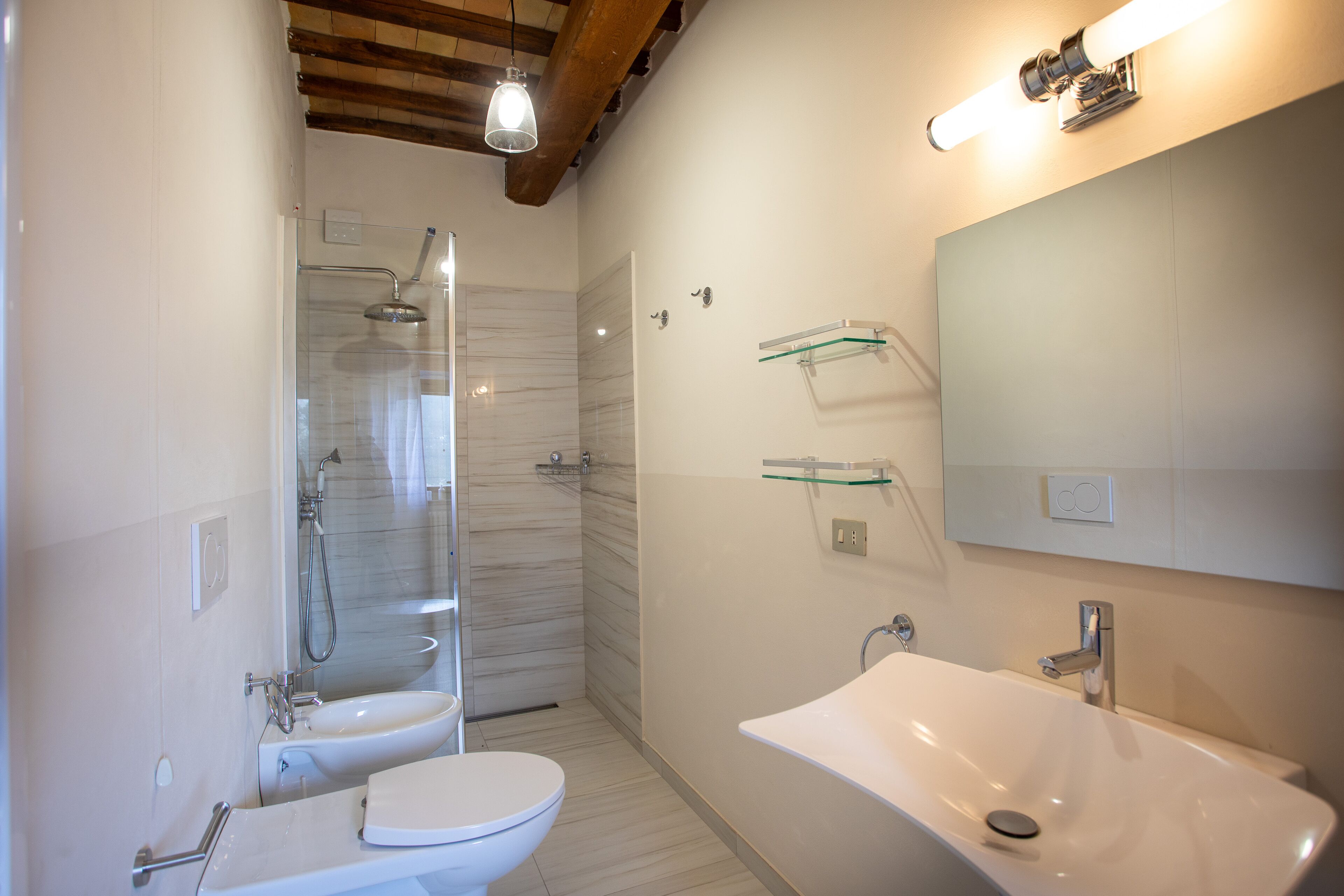 A modern bathroom with a shower, toilet, and sink.