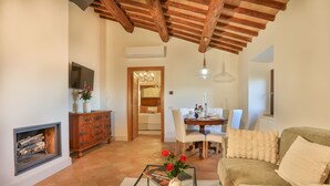 Una sala de estar acogedora con chimenea, una mesa de comedor y un sofá.