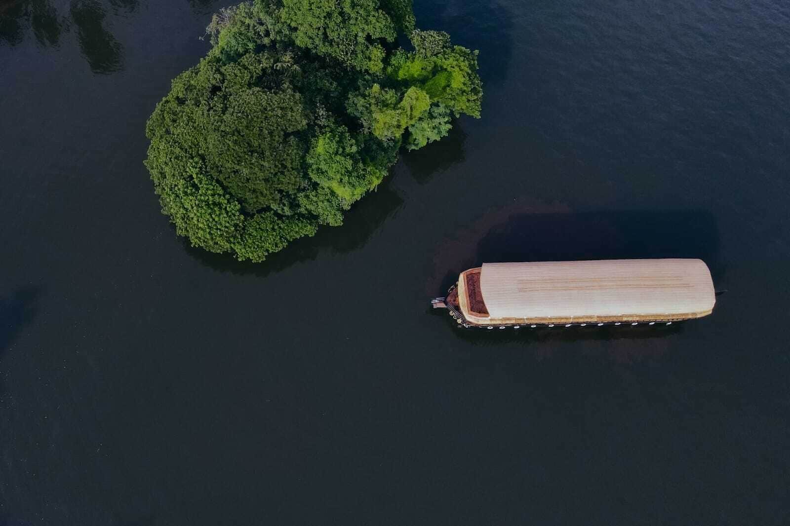 Un bote en una masa de agua con una isla boscosa cerca.