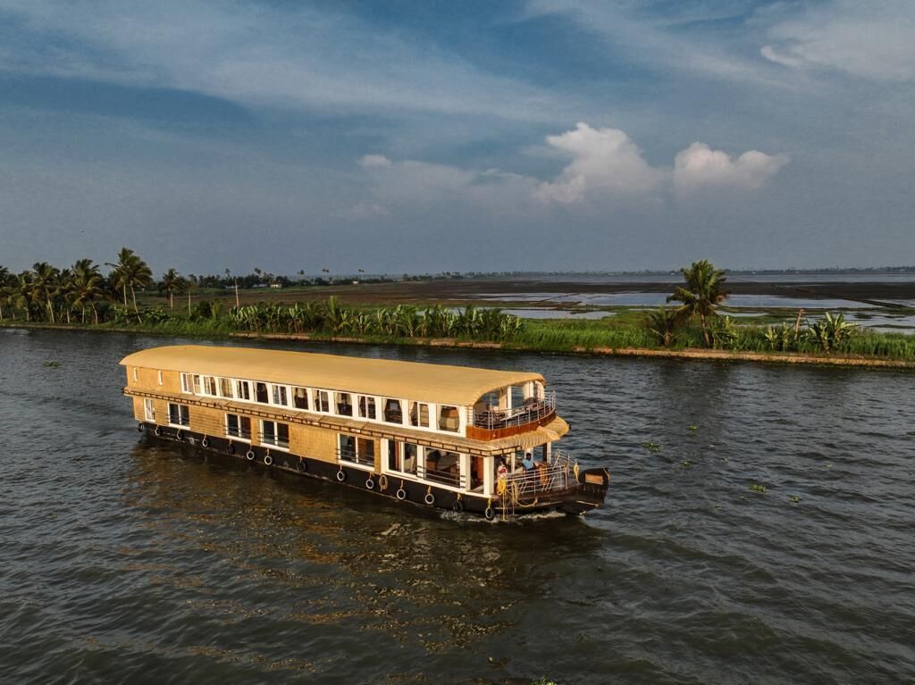 Een rivierboot met een plat dek en meerdere ramen, drijvend op rustig water.
