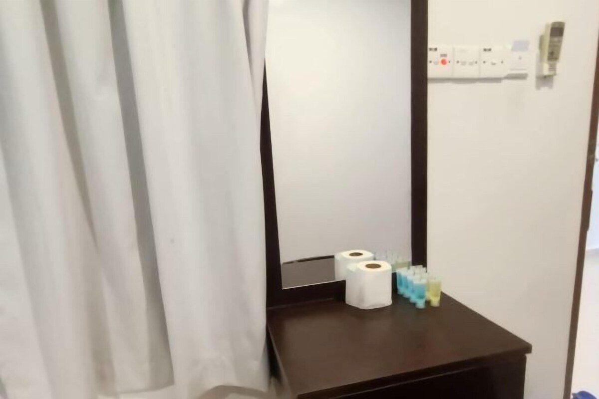 A bathroom with a mirror, a towel rack, and a shelf with toilet paper and a tissue box.