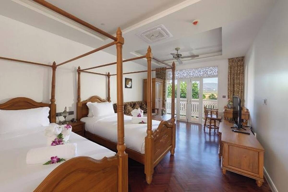 Ein Schlafzimmer mit Himmelbett, Balkon und Schreibtisch.
