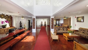 A spacious lobby with a red carpet, wooden furniture, and decorative elements. - Lanna Inthan Hotel & Resort (Doi Saket)