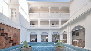A courtyard with a pool, white architecture, and multiple balconies. - Lanna Inthan Hotel & Resort (Doi Saket)