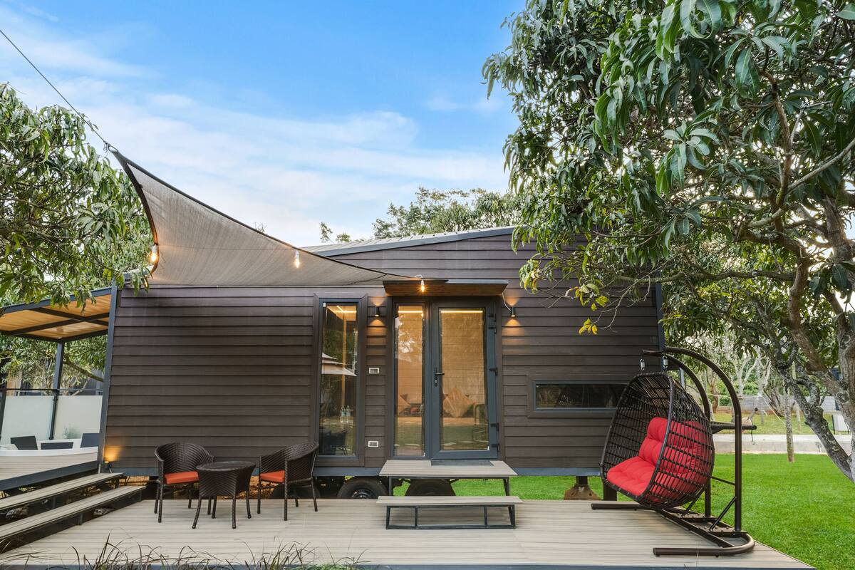 A modern house with a patio, a swing chair, and a dining area.