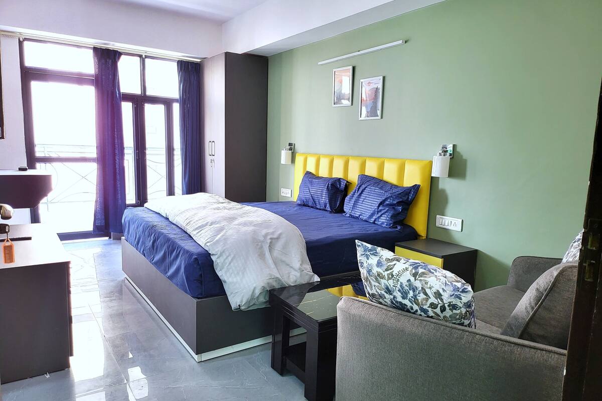 Un dormitorio moderno con una cama, un sofá y un escritorio.