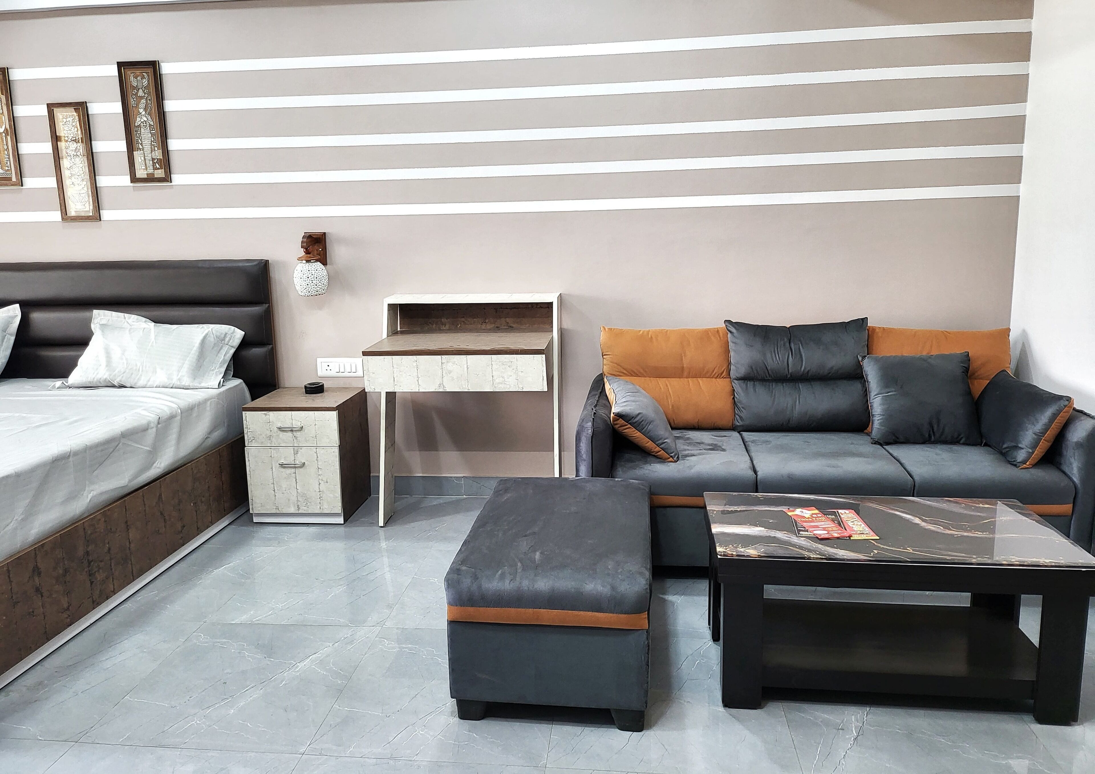 A modern living room with a bed, a sofa, a coffee table, and a desk.