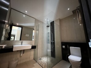 A modern bathroom with a glass-enclosed shower, a toilet, and a sink with a mirror above it. - Mio Boutique Hotel Melaka (Malacca City)