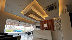 A modern hotel lobby with a reception desk, seating area, and a large chandelier. - Mio Boutique Hotel Melaka (Malacca City)