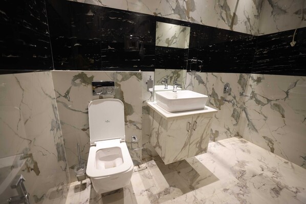 A bathroom with a toilet, sink, and mirror.