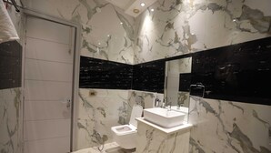 Een badkamer met toilet, wastafel en spiegel.