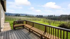 A wooden deck with a bench overlooking a vineyard. - Picturesque Vineyard and Valley Views, Quiet and Private Setting, Huge Deck, *Complimentary Wine* (Newberg)