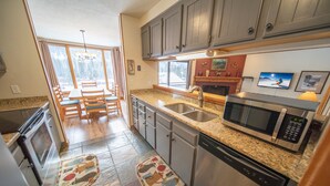 A kitchen with granite countertops, stainless steel appliances, and wooden cabinets. - Montezuma 1763 (Keystone)