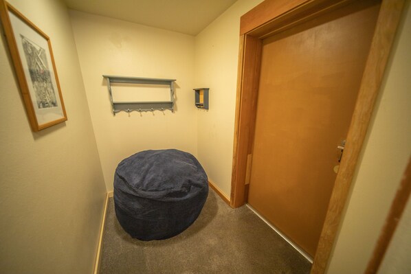 A narrow hallway with a wooden door, a small shelf, and a framed picture on the wall. - Montezuma 1763 (Keystone)