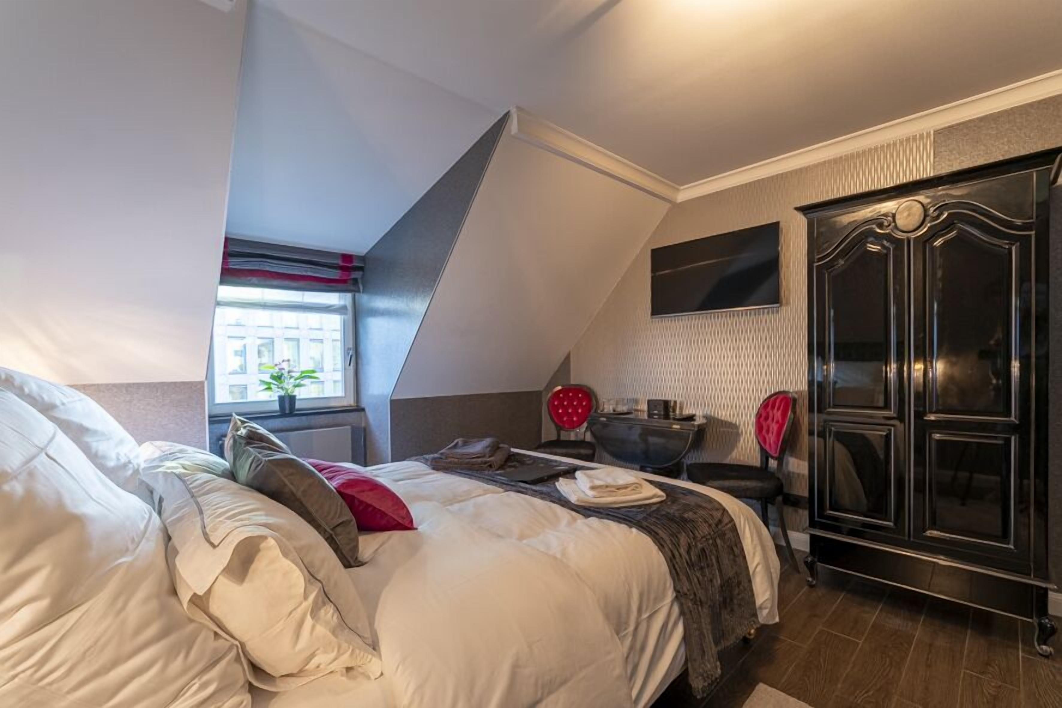 Un dormitorio con una cama grande, un armario, un escritorio y una ventana con vistas.