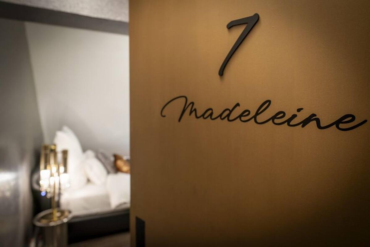 Una pared con el número 7 y el nombre 'Madeleine' en una tipografía moderna.