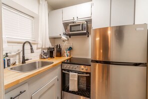 Fridge, microwave, coffee/tea maker, cookware/dishes/utensils