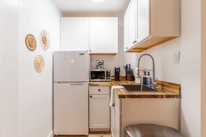 Fridge, microwave, coffee/tea maker, cookware/dishes/utensils