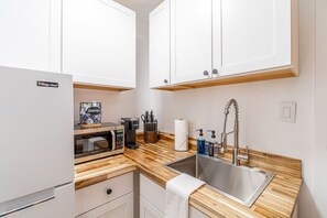 Fridge, microwave, coffee/tea maker, cookware/dishes/utensils