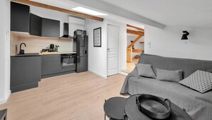 A modern apartment with a kitchen, dining area, and living room. - Le Blackwood (Mazamet)
